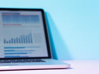 Laptop with blurred screen showing excel spreadsheet data